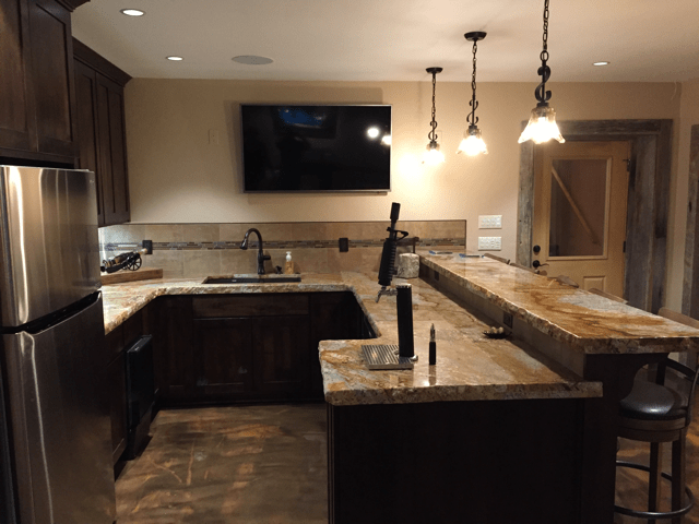 Granite countertops, recessed lighting, and bar area